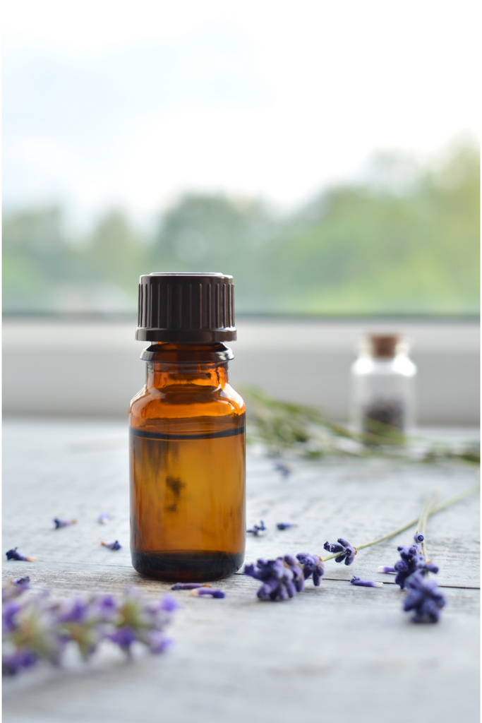 essential oil bottle with lavender flowers around it
