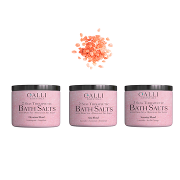 Three jars of Galli Essentials bath salts with a small pile of pink bath salts on a white background.