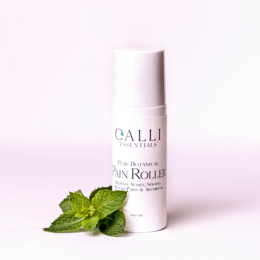 white bottle indicating pain roller with peppermint leaves beside